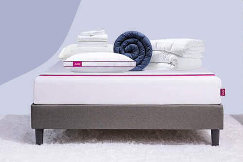 A series of bedding items and pillows lay on top of a Juno mattress for the Build a Bundle promotion. 